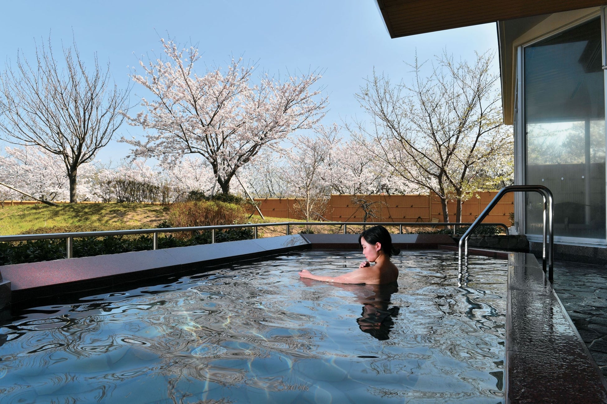 春うららの福井県　日本海を望むホテルでお花見をどうぞ！休暇村越前三国の芝生園地では３種の桜が花リレー　４月には桜の名所を訪ねるツアーも実施しますのサブ画像3_青い海と空、桜のピンクが美しい花見露天風呂