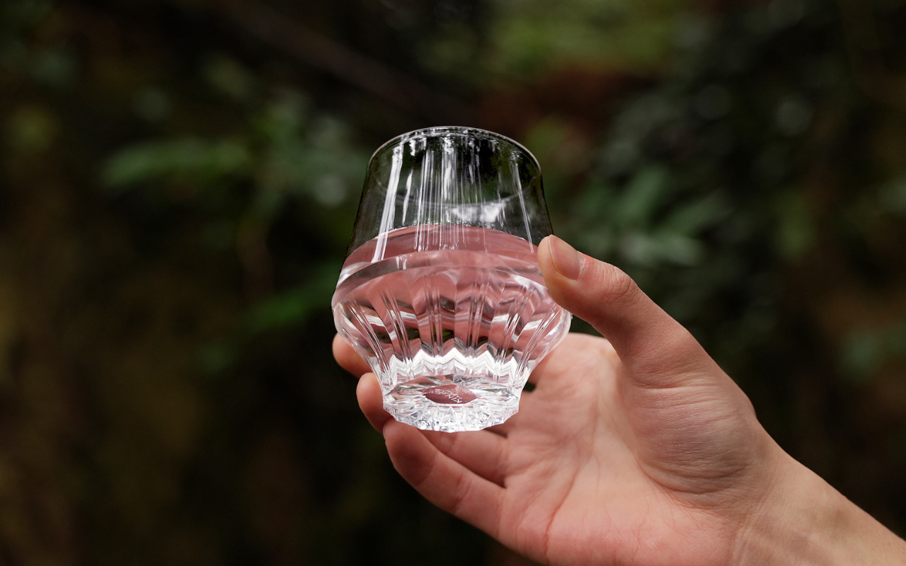 【新商品】サステナブルでデザイン性に富んだ“割れないグラス”４月15日より一般販売開始のサブ画像3_画像の説明：森を背景に水の入ったKINJO JAPAN F0を手に持っている